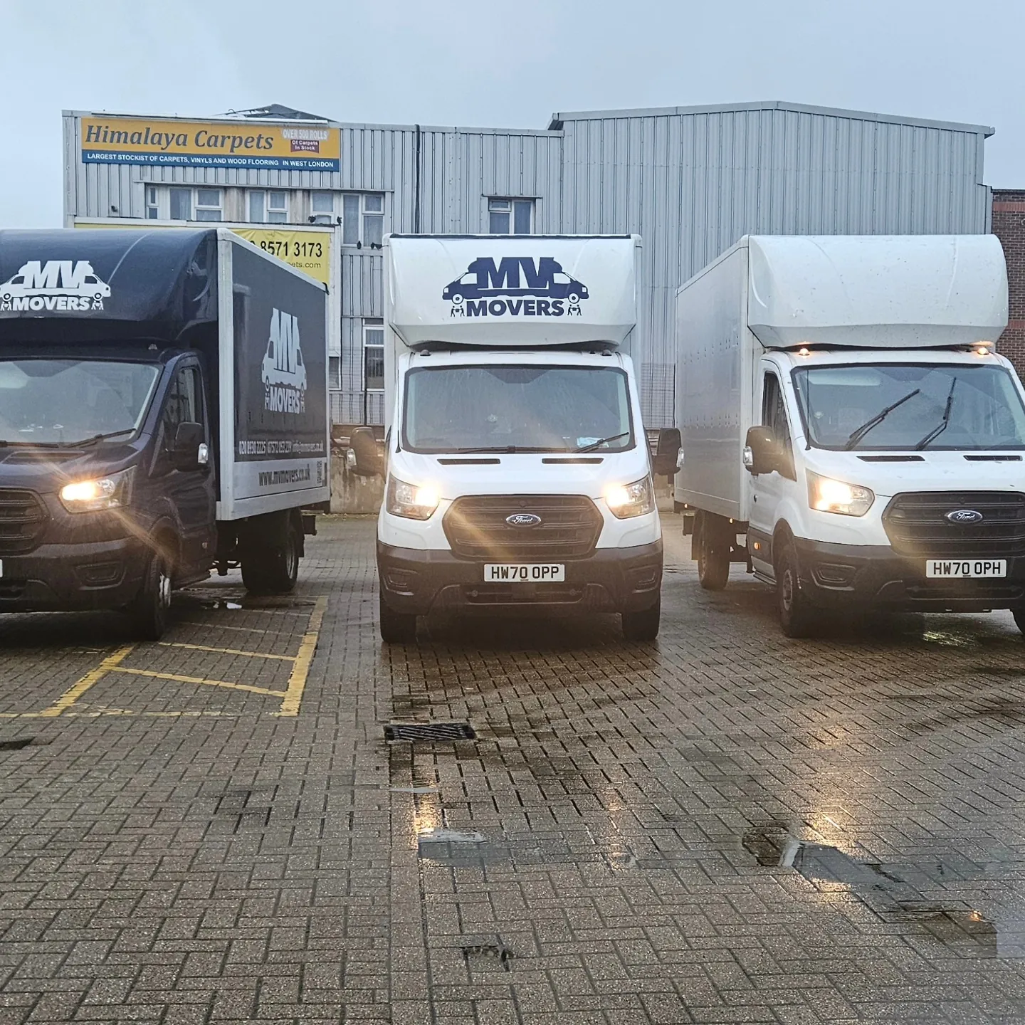Three MV Movers vans in the yard